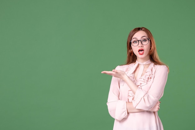 Front view female teacher in pink blouse on green background school color library college work job woman student book lesson