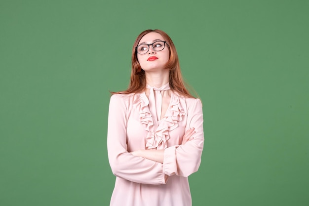 Front view female teacher in pink blouse on green background school colors library college work job woman student young book lesson