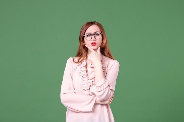 Front view female teacher in pink blouse on green background work book student job school library woman young college colors