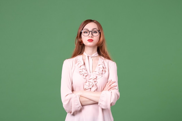 Front view female teacher in pink blouse on green