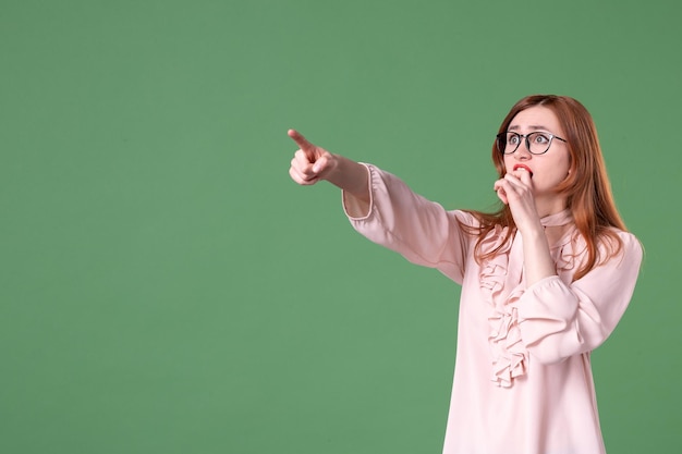 Front view female teacher in pink blouse posing on green background job school woman color young student library college work lessons book