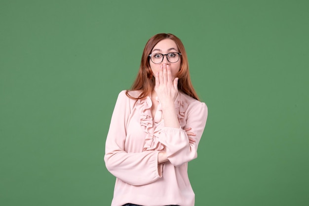 Front view female teacher in pink blouse surprised on green