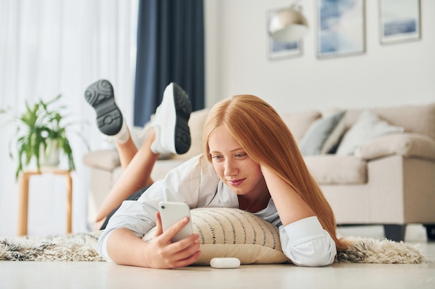 Front view Female teenager with blonde hair is at home at daytime