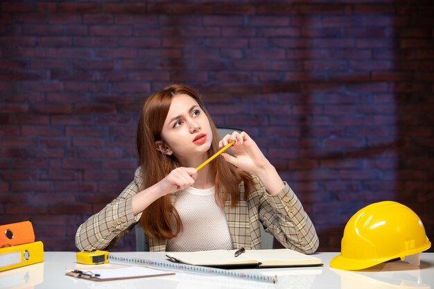 front view female worker in construction site sitting behind table agenda engineer business job plan manager