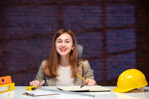 front view female worker in construction site sitting behind table agenda engineer corporate business job plan managers