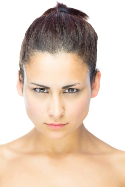 Front view of focused young woman gazing at camera