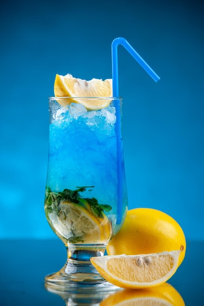 Foto vista frontale cocktail fresco e fresco con limone e ghiaccio su sfondo blu bevanda fredda colore limonata bar succo d'acqua