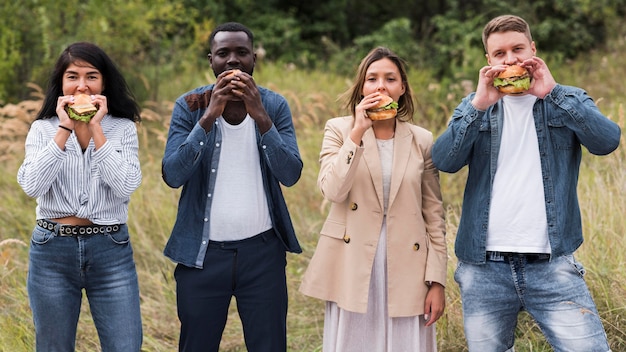 Front view friends eating burgers