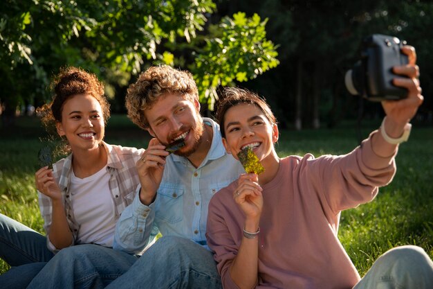 Foto amici di vista frontale che mangiano snack di alghe