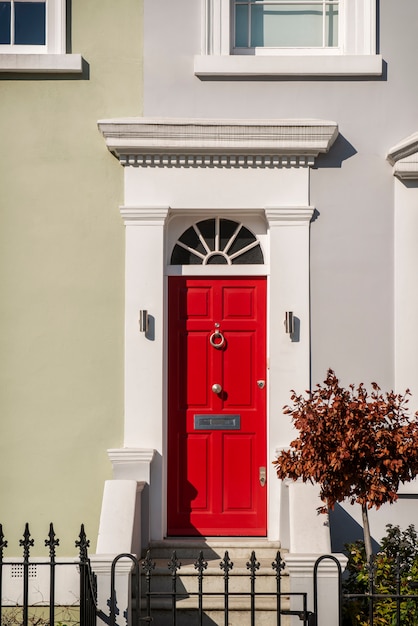 Front view of front door with beige wall and plants