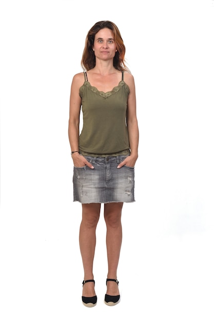 Photo front view of the full portrait of a woman in a denim skirt on white background, hands on pocket