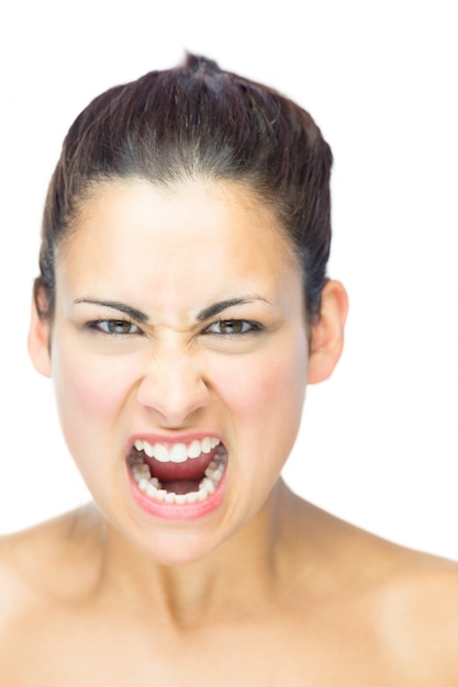 Front view of furious brunette woman yelling at camera 