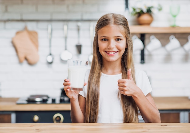 写真 牛乳のガラスを保持している正面の女の子