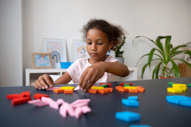 Front view girl making puzzle at table