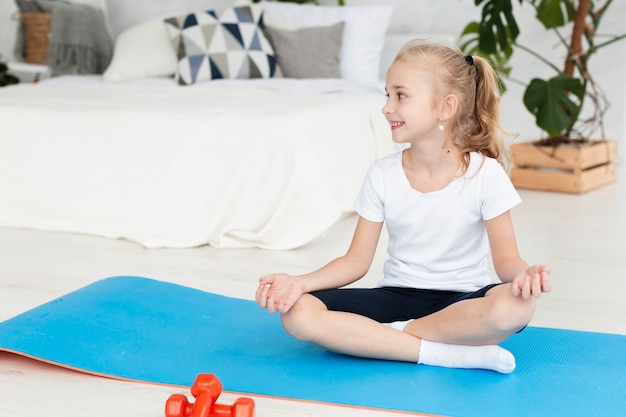 Photo front view of girl on mat practicing yoga