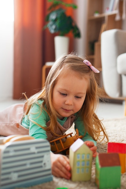 Photo front view girl playing at home