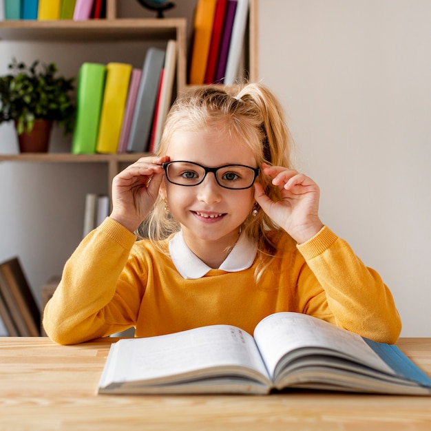 Photo front view girl with glasses reading