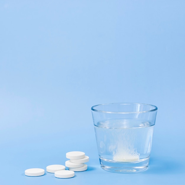 Photo front view of glass of water with effervescent tablet and copy space