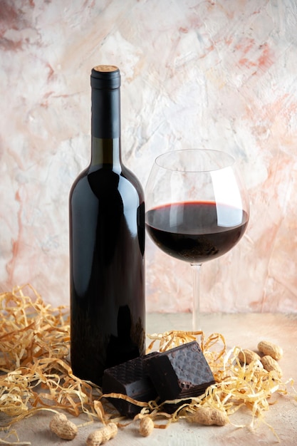 Front view glass of wine with bottle and chocolate on a light background alcohol lemonade holiday bar champagne juice drink