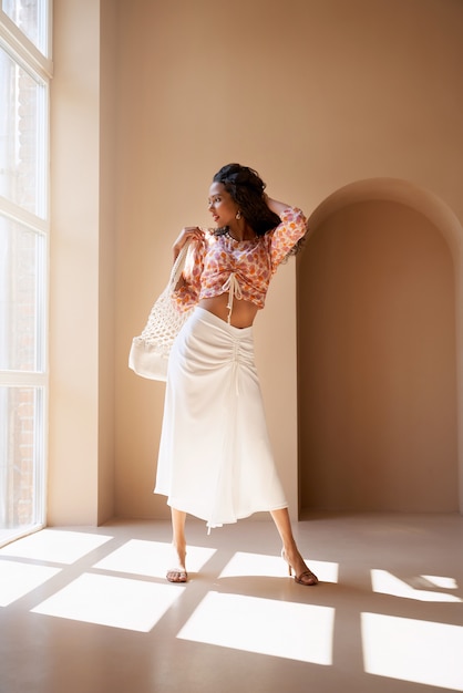 Front view of gorgeous half african young brunette model wearing fashionable summer clothes and sandals on heels.