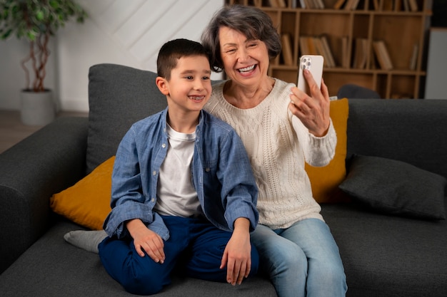 Photo front view grandmother and boy taking selfie