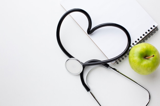 Front view green apple and heart shaped stethoscope