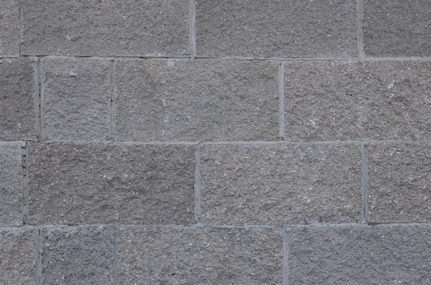 Front view of grey brick wall texture . Tiled concrete cement surface.