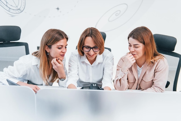 Front view of group of business women in formal clothes indoors in the office