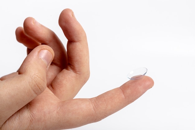 Front view of hand holding contact lens on finger