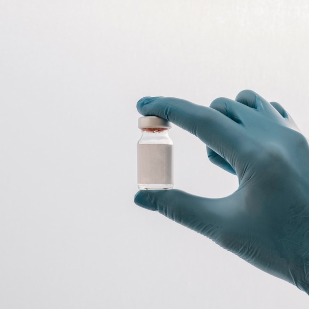 front view of hand with glove holding vaccine