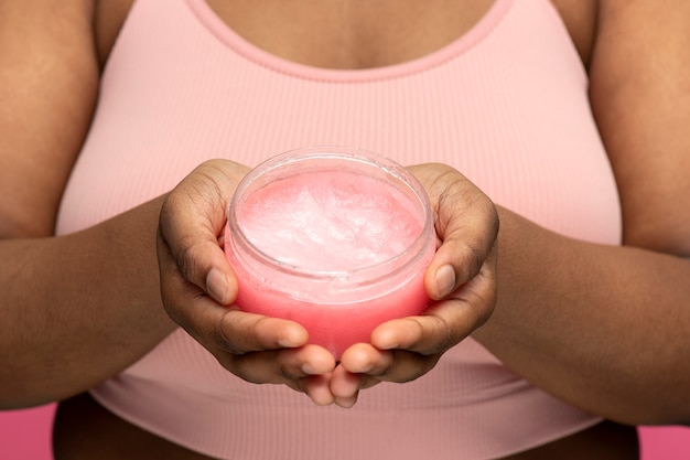 front view hands holding cream container