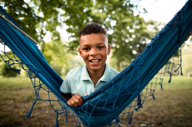 Photo front view of happy boy in hammock