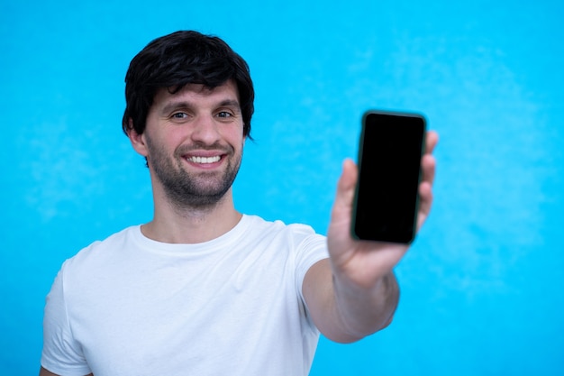 Front view of a happy man showing a blank smart phone display