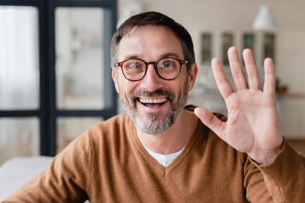 Front view of a happy mature man father husband freelancer talking on video call online conversation conference meeting remotely Good connection elearning concept