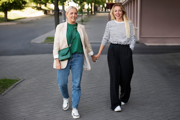 Photo front view happy women holding hands