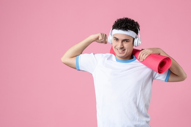 Photo front view happy young male in sport clothes with yoga mat