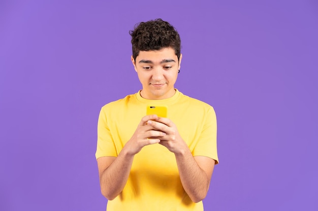 Front view of hispanic teenager boy using phone