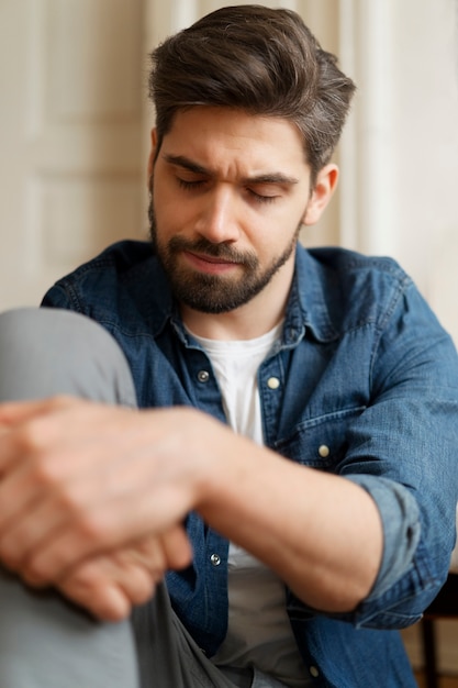 Photo front view insecure man sitting on floor