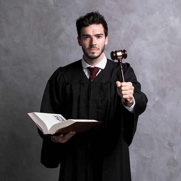 Photo front view judge holding book and gavel