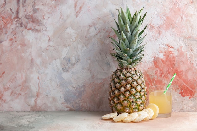 Vista frontale succo in pipetta di vetro ananas secco anelli ananas su sfondo beige spazio libero