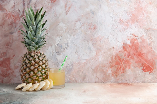 Vista frontale succo in pipetta di vetro ananas secco anelli ananas su sfondo beige spazio libero