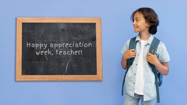 Photo front view kid with blackboard