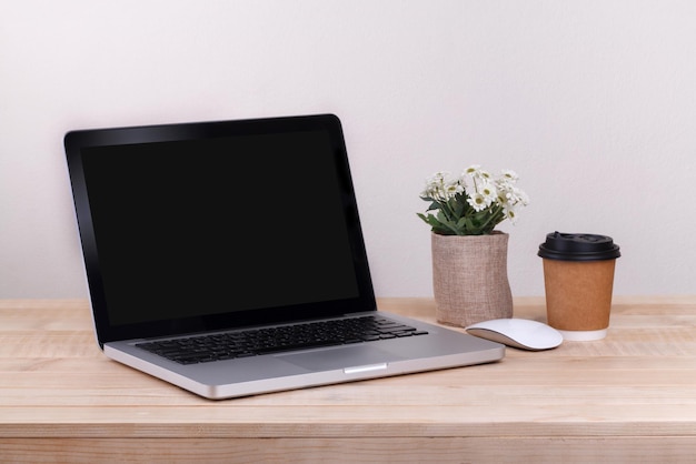 Front view of the laptop and coffee is on the work table concrete background