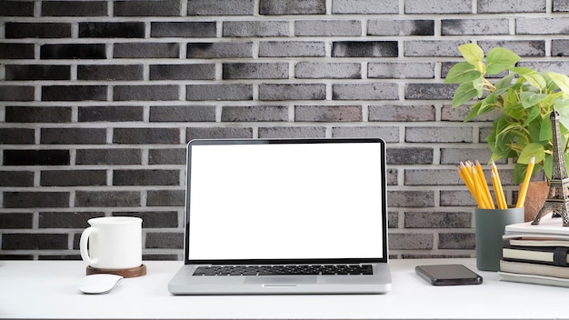 Front view laptop computer coffee cup stationery and houseplant on white table Home office desk Blank screen for your advertise text