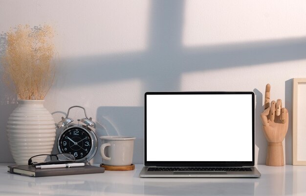 Photo front view laptop computer with empty screen on white table in bright room