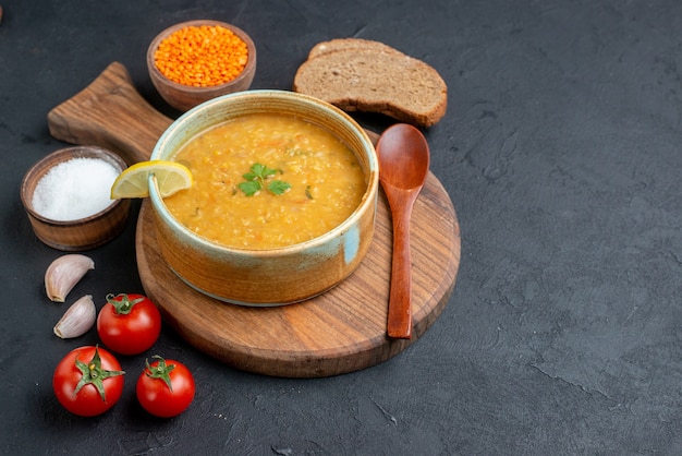 Front view lentil soup with salt raw lentils and dark bread loafs on dark surface