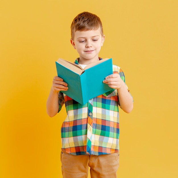 Photo front view little boy reading