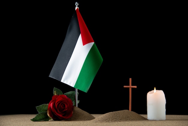 Front view of little grave with palestinian flag on black