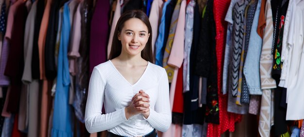 Vista frontale guardare avanti sguardo felice tenendosi per mano dita incrociate giovane ragazza adolescente nel negozio di abbigliamento