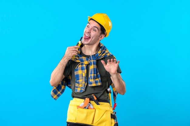 вид спереди мужчина-строитель в шлеме с различными инструментами на синем фоне здание плоская архитектура конструктор строитель дом рабочий работа